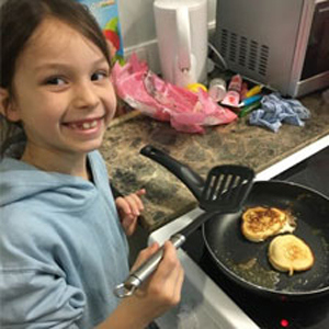 Photo of girl cooking with a frying pan