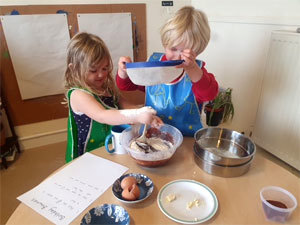 Two children mixing flour