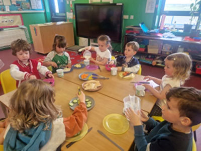 Photo of children eating vegetables around table