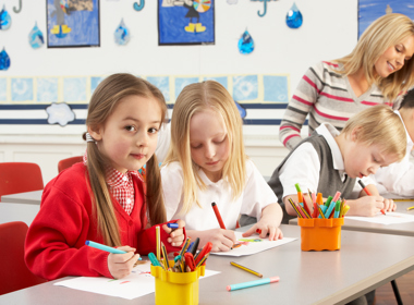 Two girls in a classroom drawing