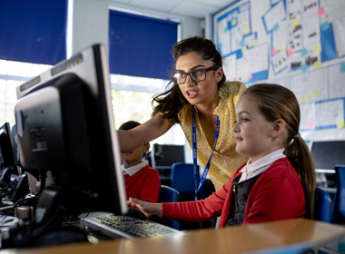 Teacher interacting with a child on a computer